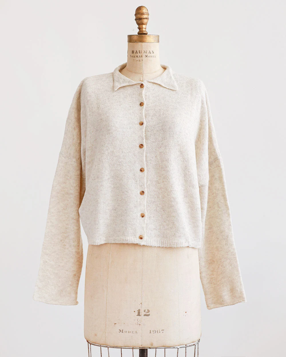 Cream buttoned knit cardigan on a dress form
